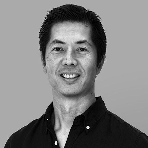 Smiling Asian man wearing a black shirt, with a friendly expression.